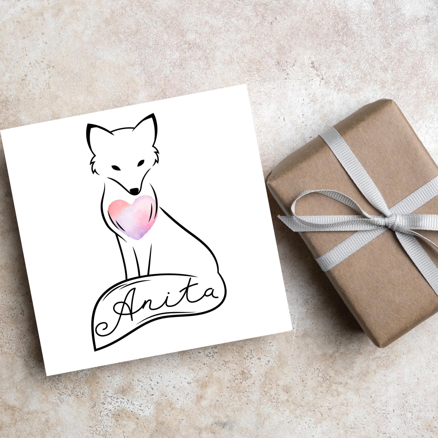 Square card with simple black line drawing of a fox sitting with its tail wrapped around its feet. It has a pink watercolour heart on its chest and personalised with a name on the tail in a calligraphy font