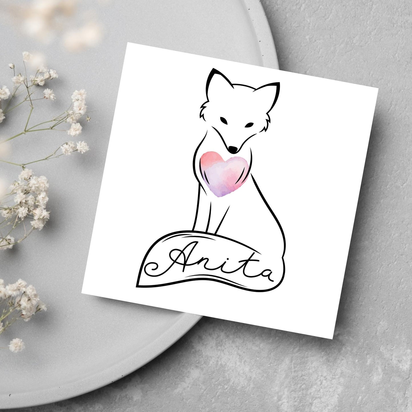 Square card with simple black line drawing of a fox sitting with its tail wrapped around its feet. It has a pink watercolour heart on its chest and personalised with a name on the tail in a calligraphy font