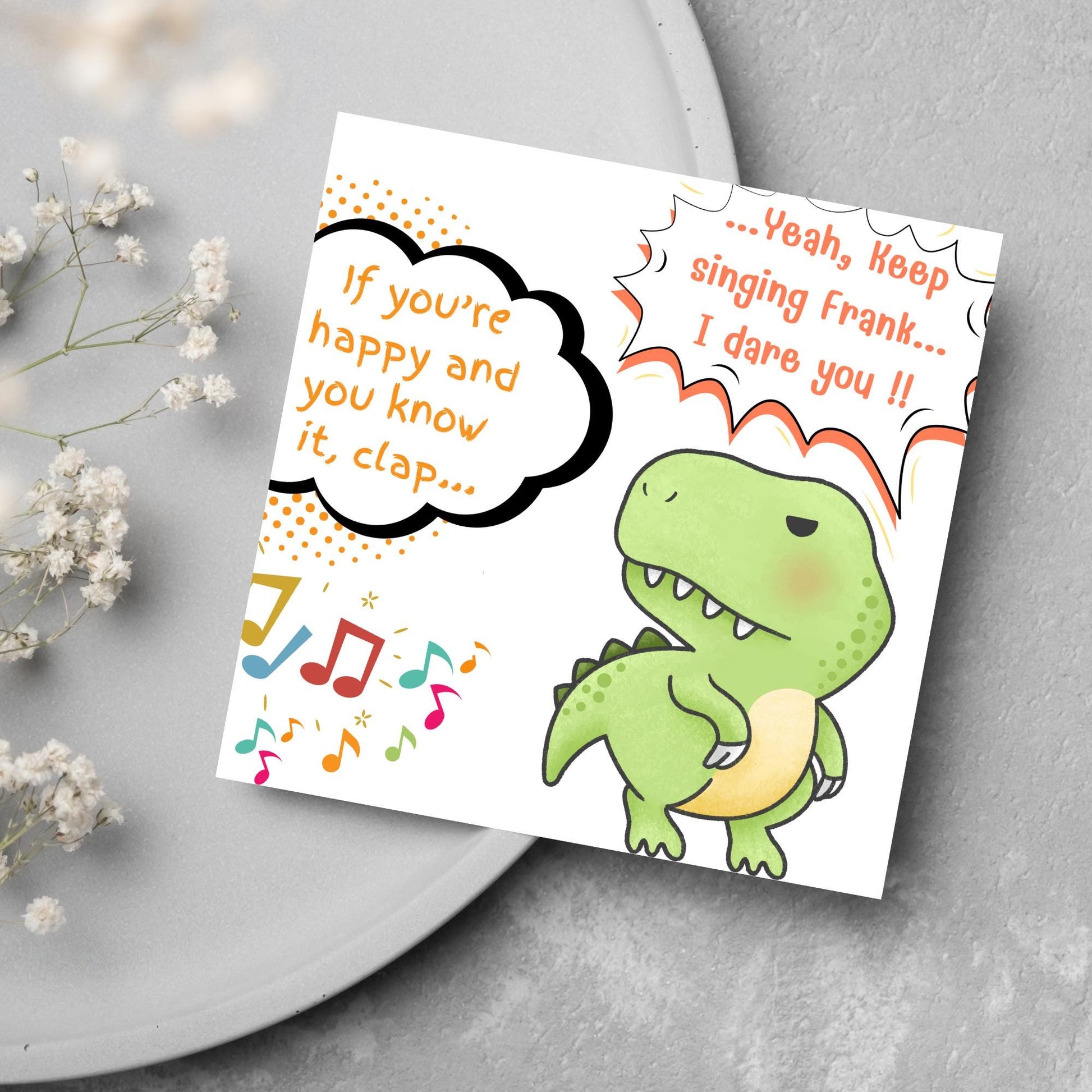 A cute, grumpy green T-Rex with tiny arms is featured. Text reads, "If you're happy and you know it, clap..." The T-Rex responds, "...Yeah, keep singing Frank... I dare you!!" Musical notes add a playful touch.