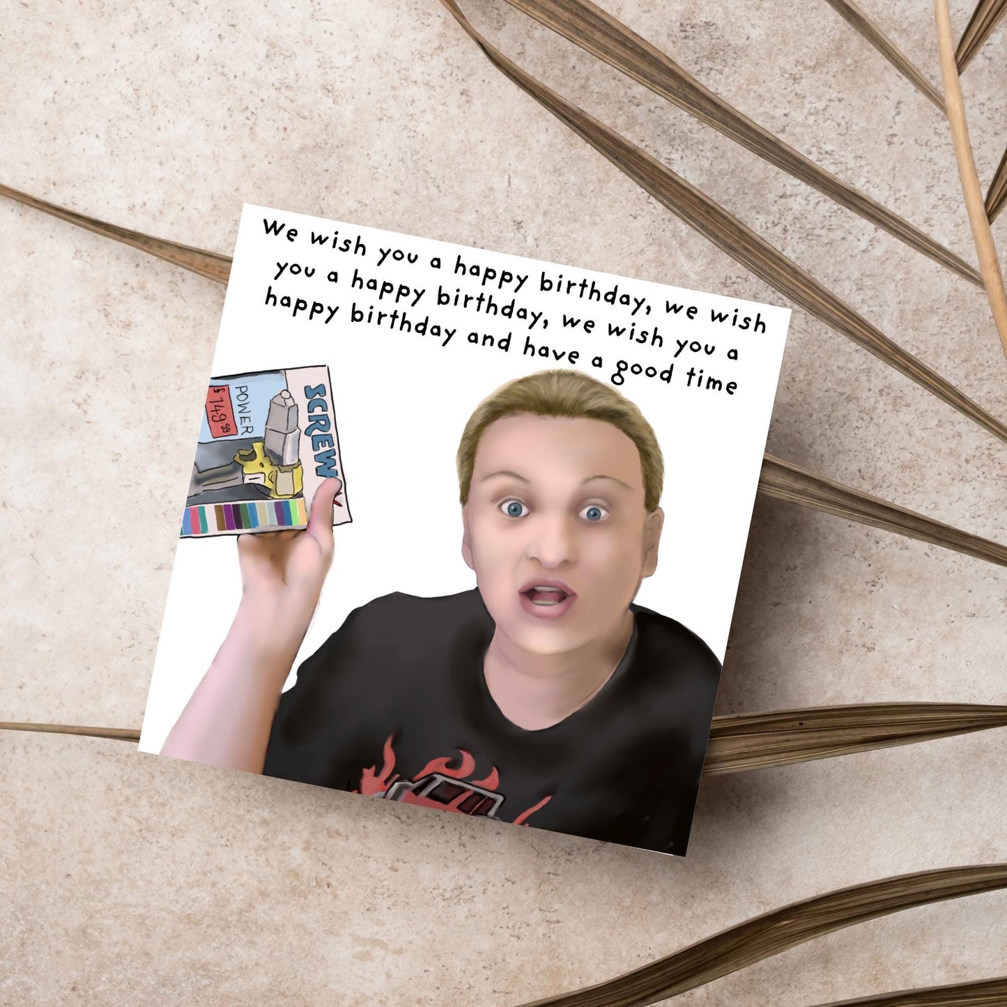 Square birthday card with a hand drawn image of Kerry from this country looking shocked and holding up a screwfix catalogue with the text we wish you a happy birthday, we wish you a happy birthday, we wish you a happy birthday and have a good time