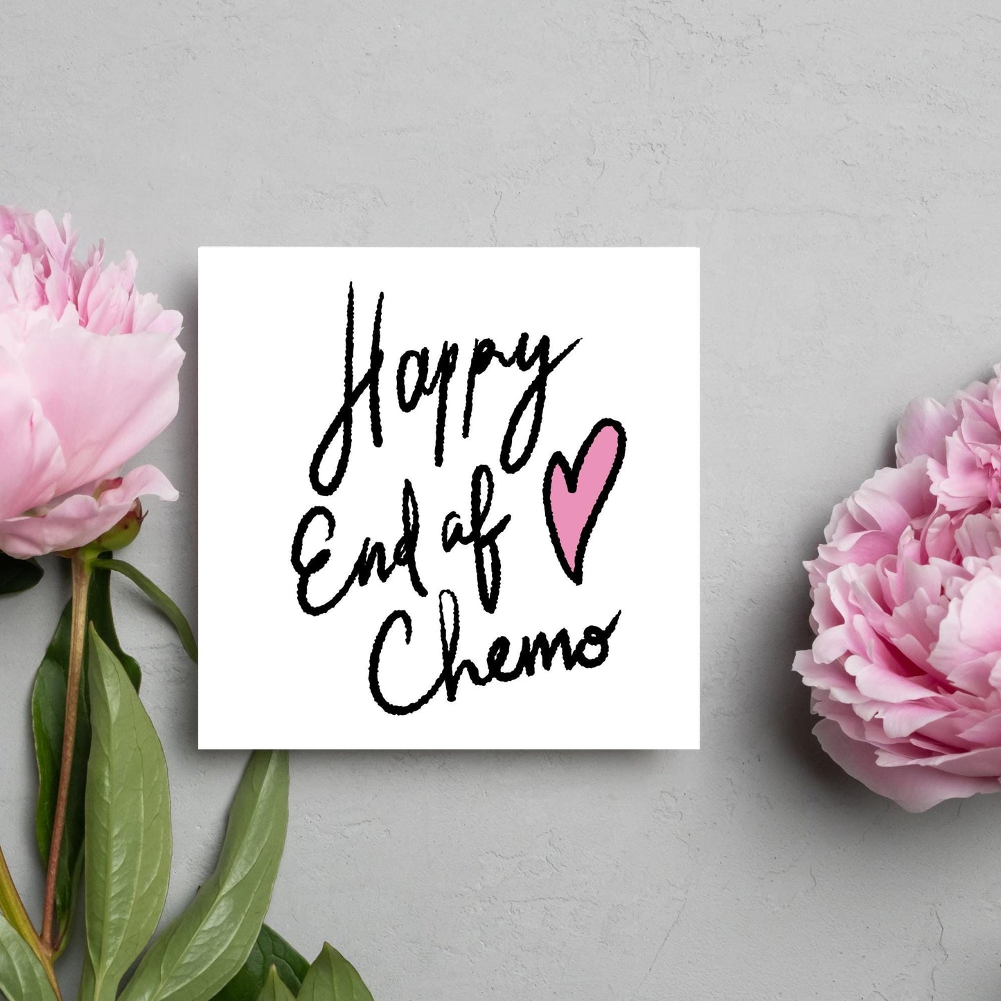 Simple square card with a white backdrop and black handwritten style text that reads HAPPY END OF CHEMO with a roughly drawn pink heart next to the text.