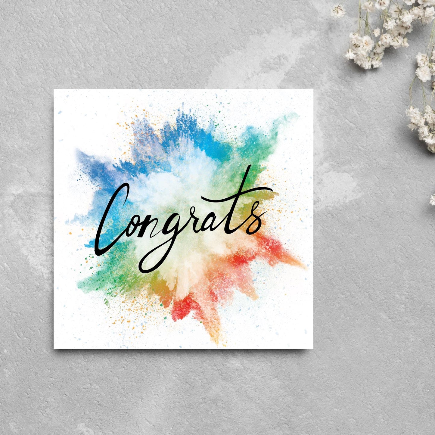 square card with rainbow paint splash against a white background. Black calligraphy style text overlay the paint with congrats