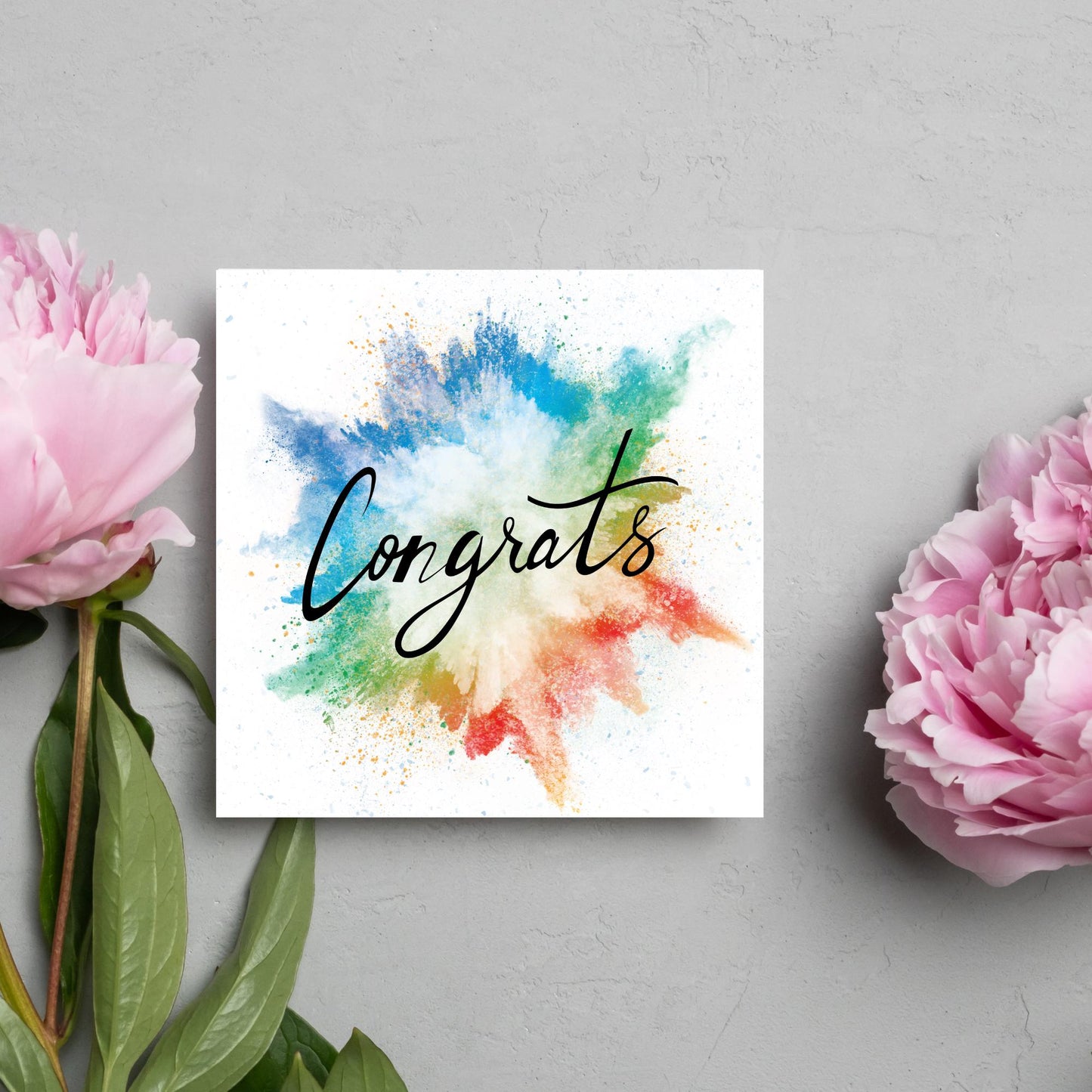 square card with rainbow paint splash against a white background. Black calligraphy style text overlay the paint with congrats