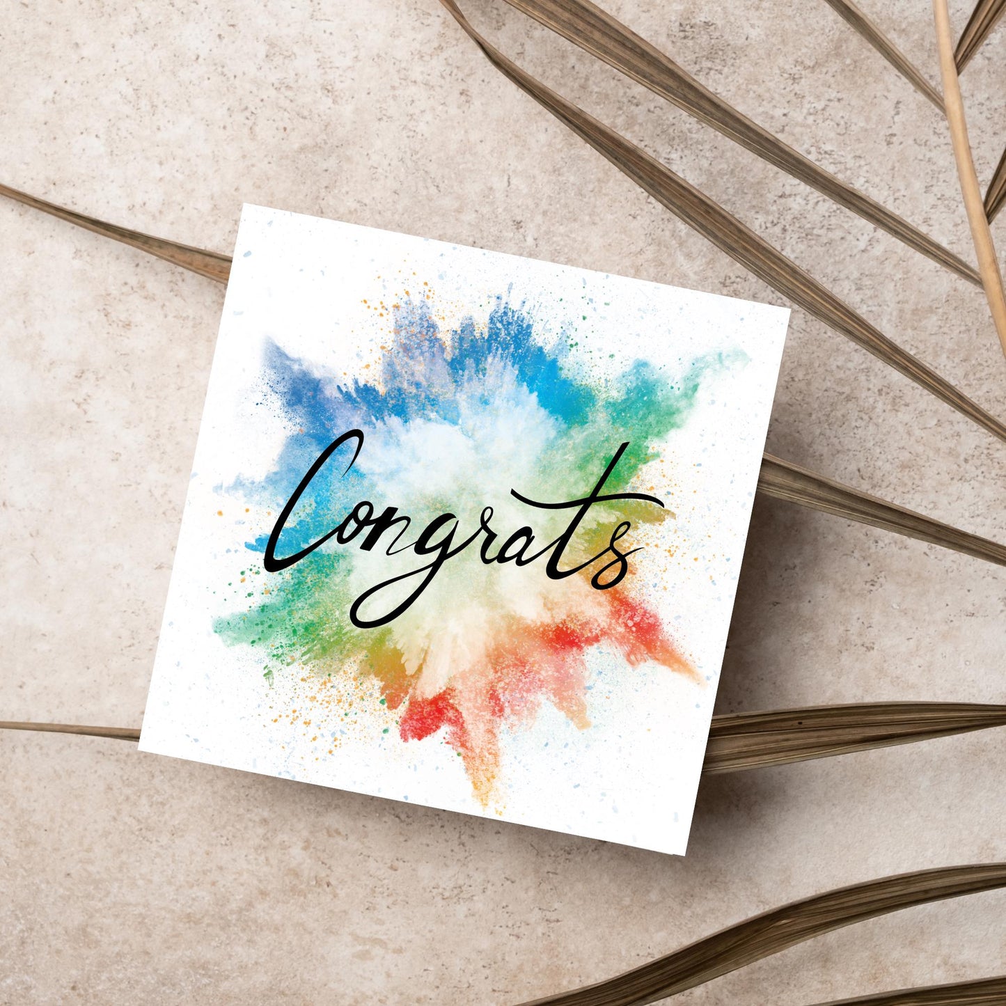 square card with rainbow paint splash against a white background. Black calligraphy style text overlay the paint with congrats