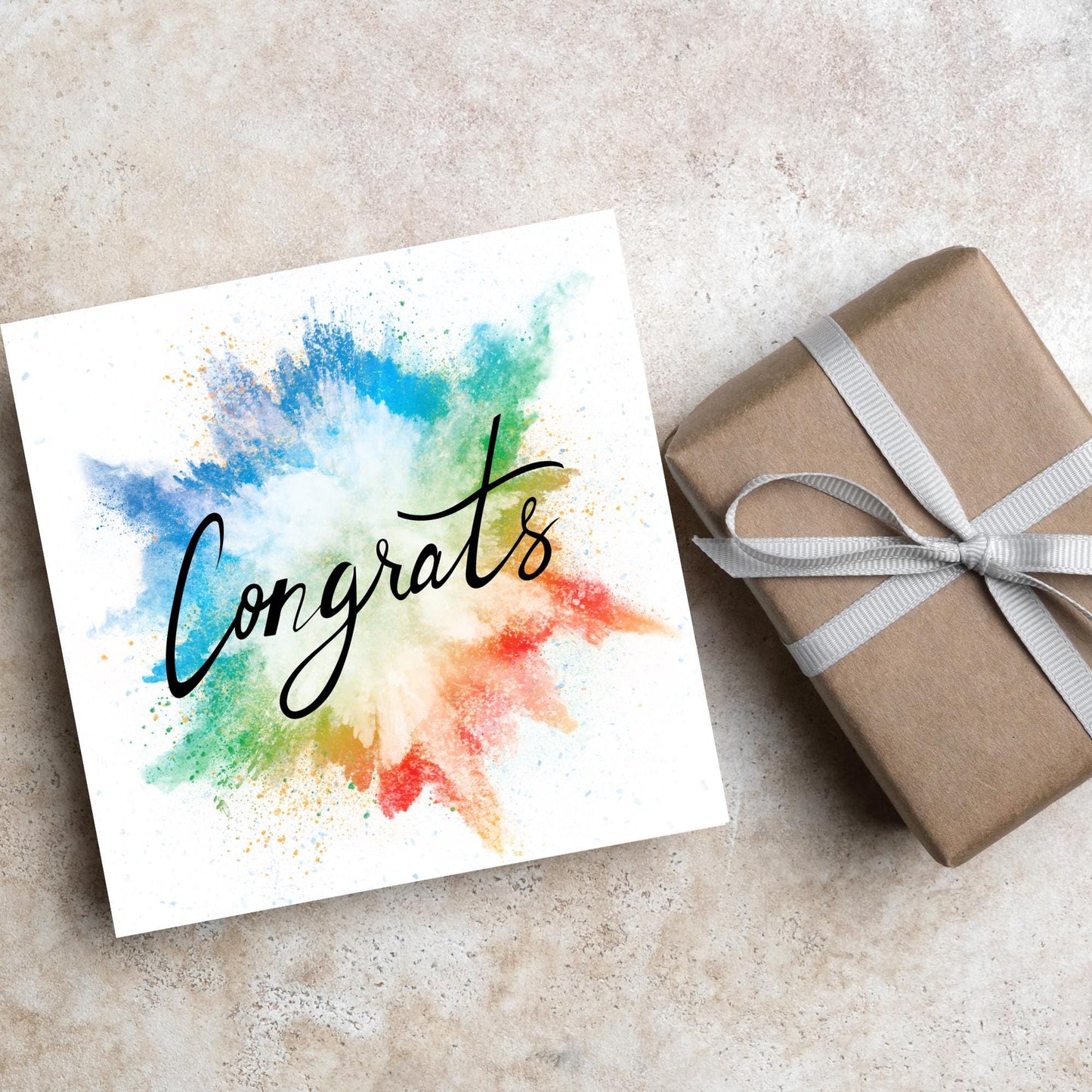 square card with rainbow paint splash against a white background. Black calligraphy style text overlay the paint with congrats