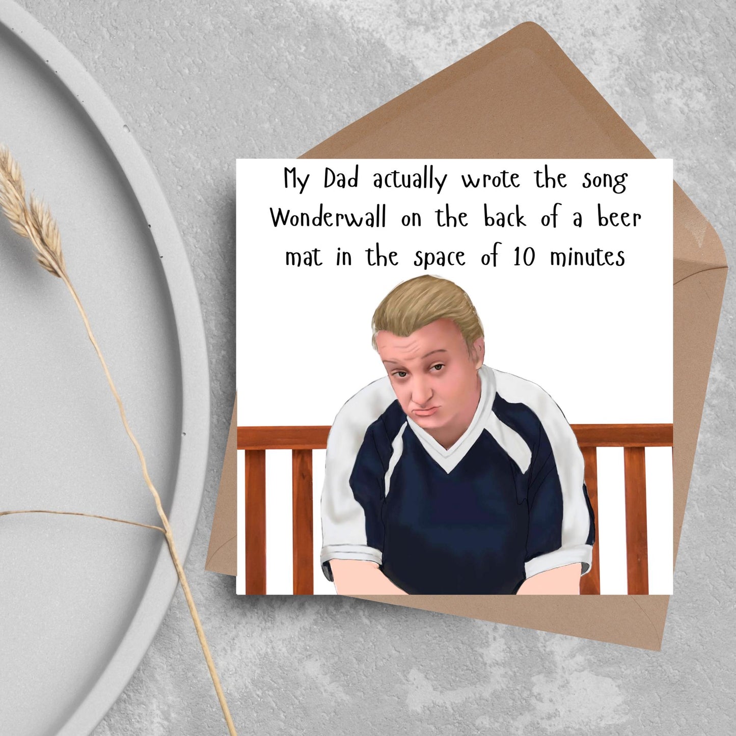 square card with a hand drawn image of kerry from this country sitting on a bench with handwritten style text above - My Dad actually wrote the song Wonderwall on the back of a beer mat in the space of 10 minutes