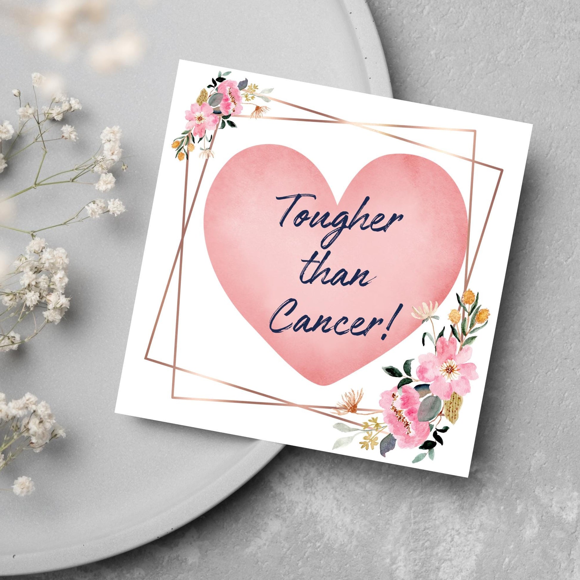 Square white card with a watercolour floral border frame and a pink heart in the centre with the text Tougher than cancer in s handwritten style navy blue font