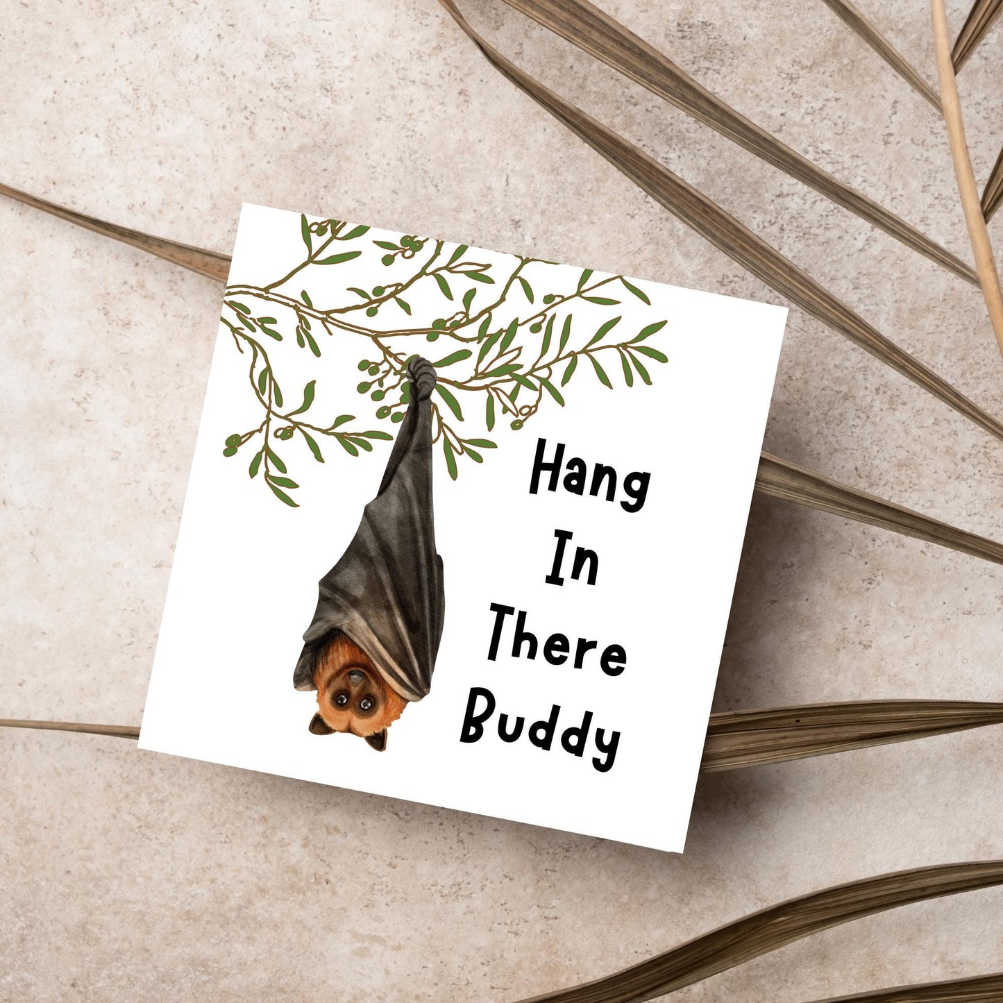 square card with an illustration of a bat hanging upside down from a tree branch with black text next to it that reads - Hang in there buddy