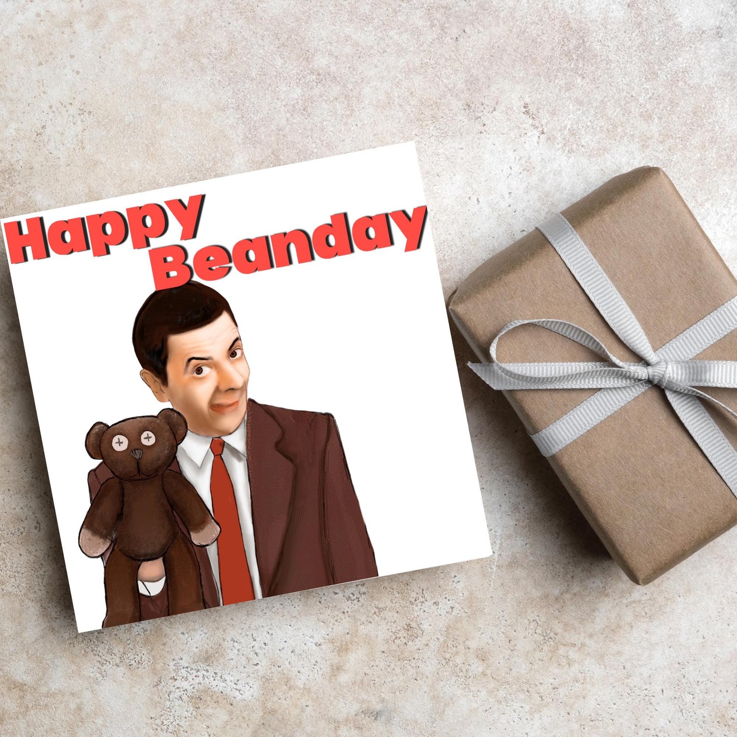 square card with a hand drawn image of Mr bean holding his teddy pooky with a cheeky smile on his face with the words Happy Beanday above in bold red text