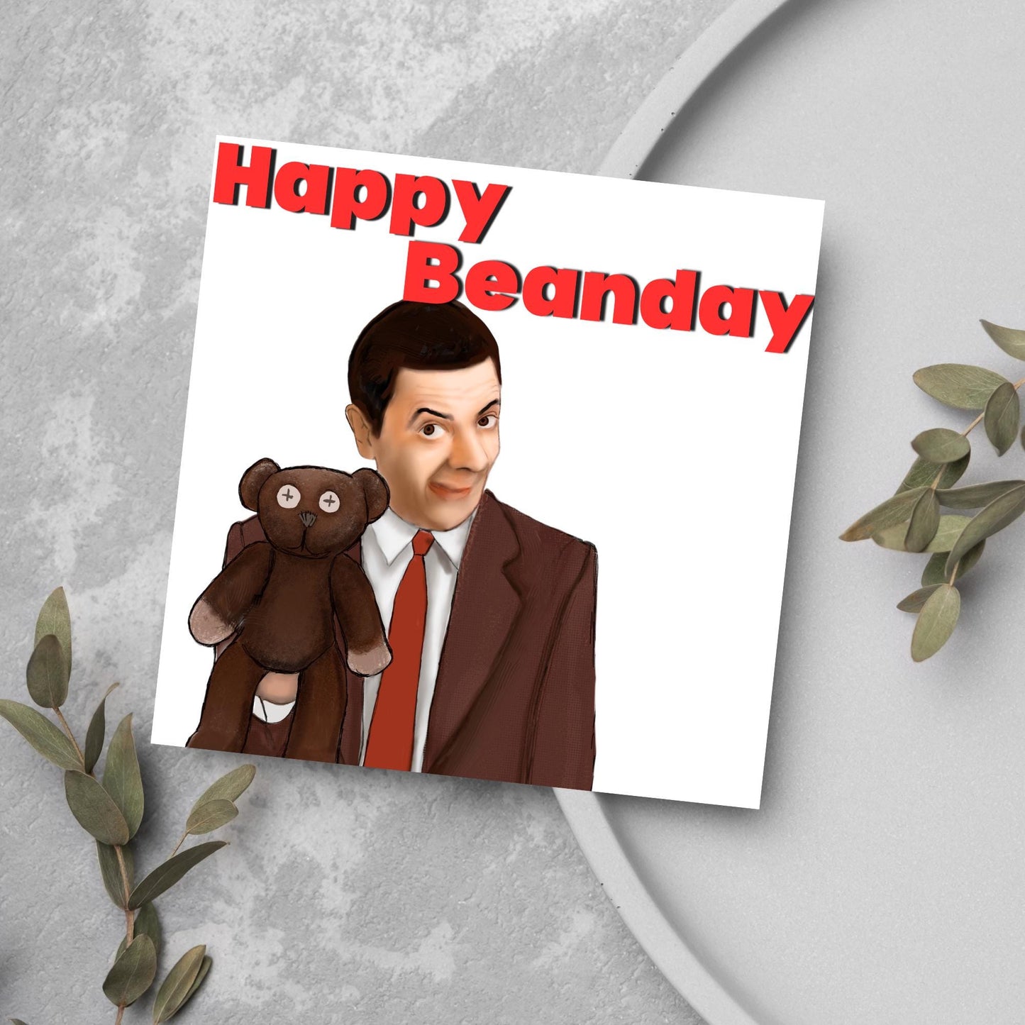 square card with a hand drawn image of Mr bean holding his teddy pooky with a cheeky smile on his face with the words Happy Beanday above in bold red text