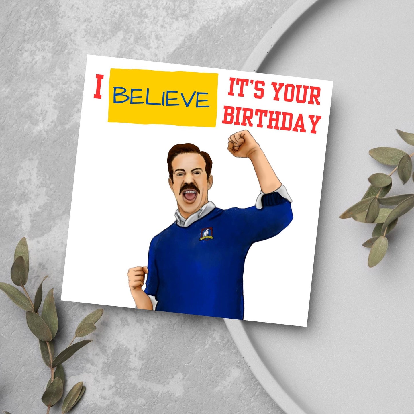 square greetings card with a hand drawn image of Jason Sudeikis character Ted Lasso giving a fist pump with the text - I believe it's your birthday
