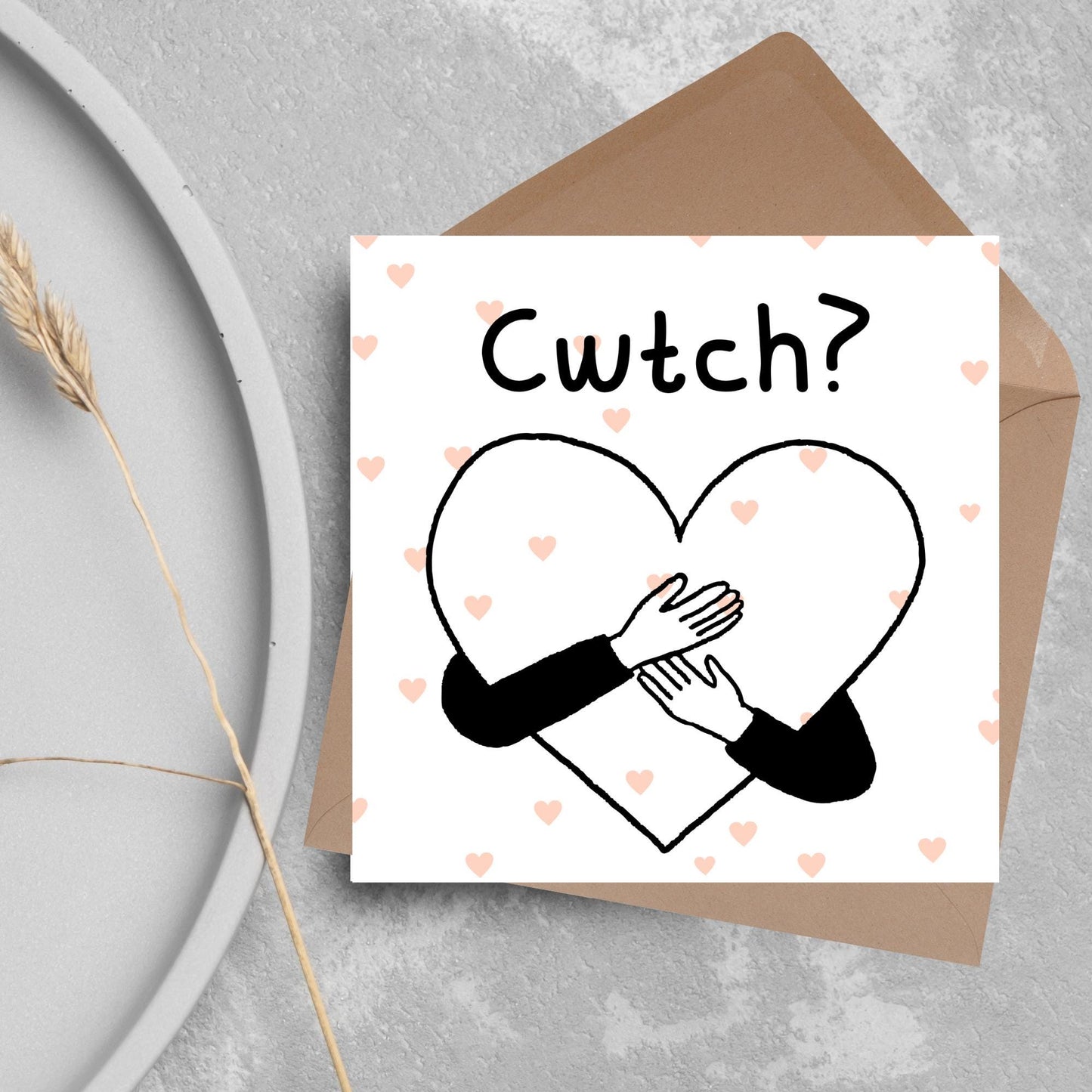 Square Greeting card small with subtle pink hearts in the background of a line drawn heart with hands hugging it and the word CWTCH? above it in handwritten style text