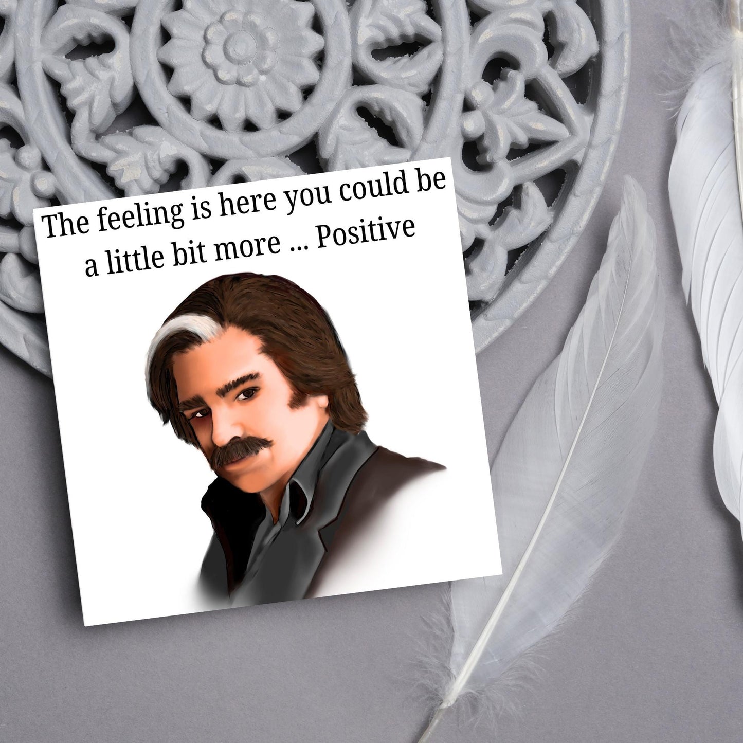 Square card with a hand drawn image of Steven Toast from the TV show Toast of London giving side eye with the text above - the feeling is here you could be a little bit more.....positive
