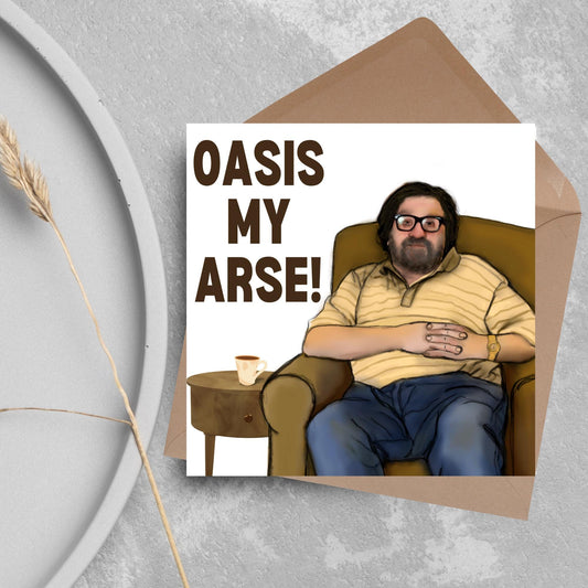 square card with a hand drawn image of Jim from The Royle Family sitting in his armchair next to a cuppa with the text - Oasis My arse in bold brown text