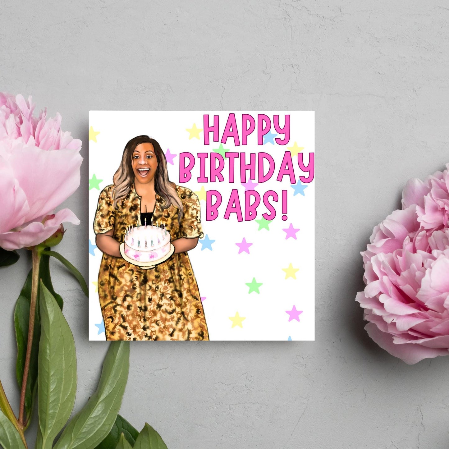 square card with a hand drawn image of Alison Hammond in a leopard print dress, holding a birthday cake and laughing joyfully with a background of multicoloured stars and Big pink text that reads HAPPY BIRTHDAY BABS!
