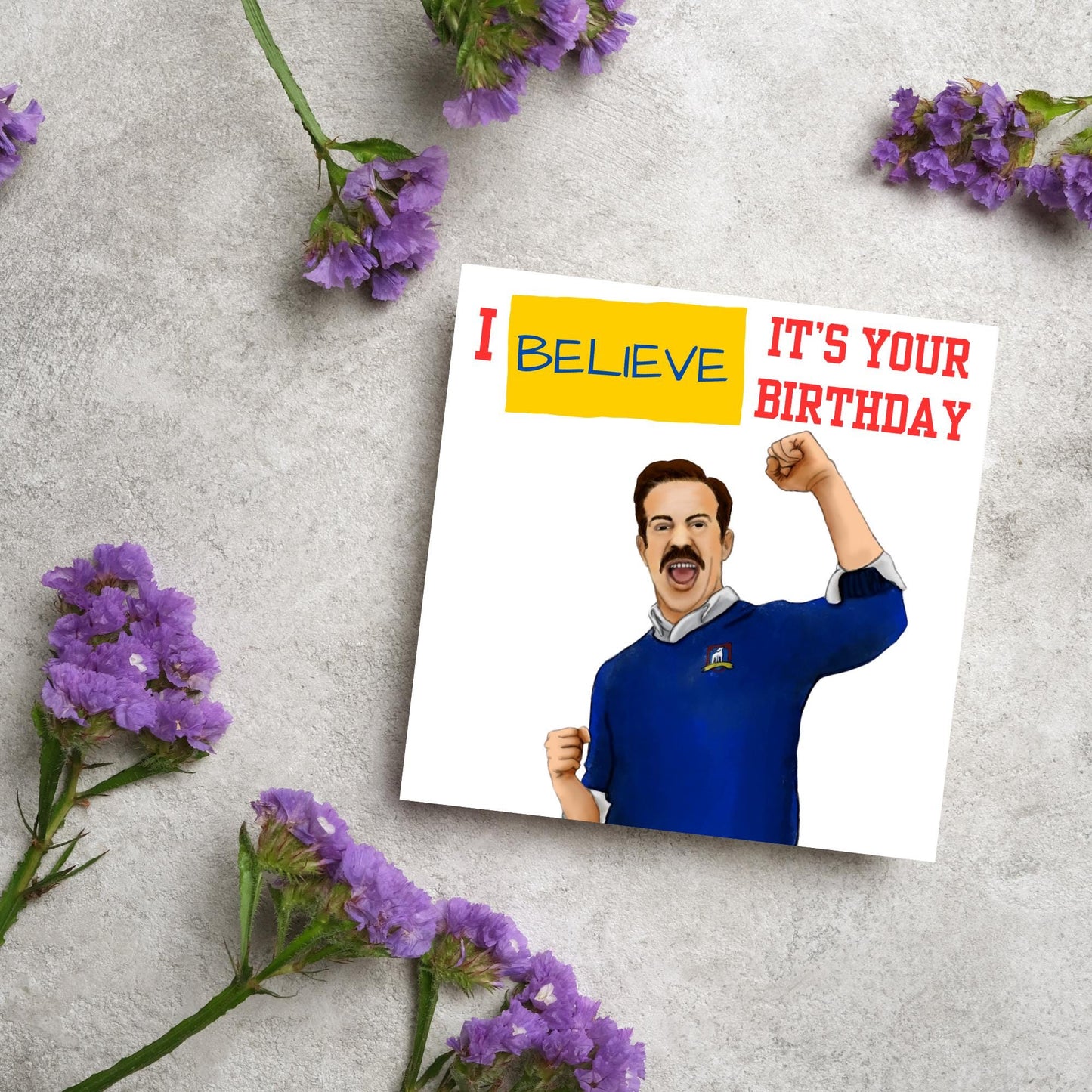 square greetings card with a hand drawn image of Jason Sudeikis character Ted Lasso giving a fist pump with the text - I believe it's your birthday