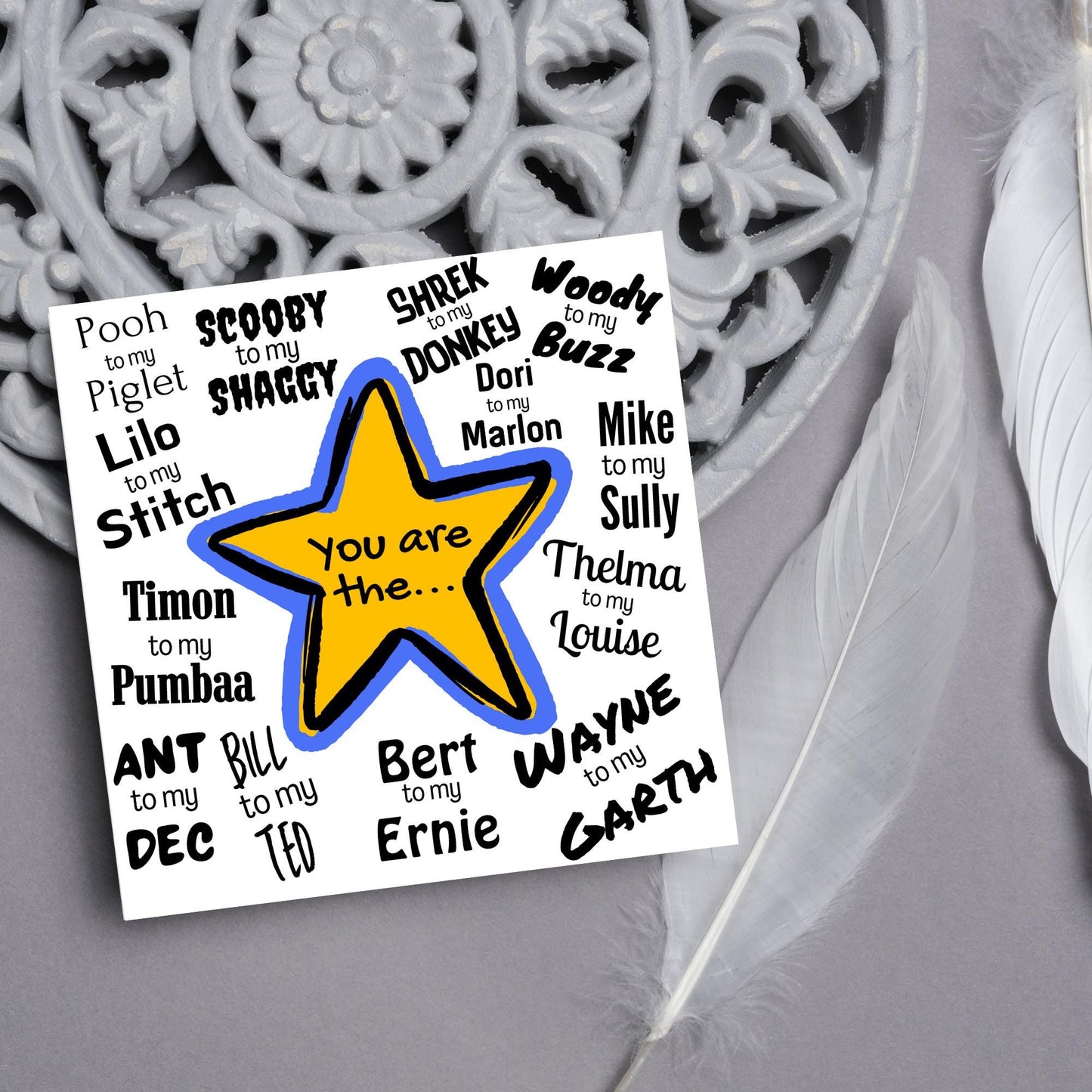 Square card with a blue and yellow star in the centre with black text - you are the... - and various famous friendship duos. for example thelma to my louise, lilo to my stitch, woody to my buzz, pooh to my piglet etc