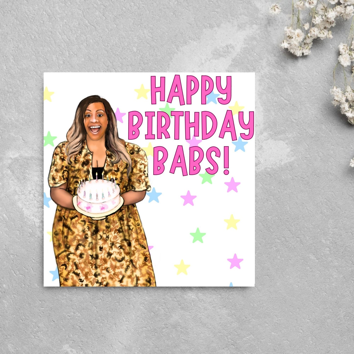 square card with a hand drawn image of Alison Hammond in a leopard print dress, holding a birthday cake and laughing joyfully with a background of multicoloured stars and Big pink text that reads HAPPY BIRTHDAY BABS!