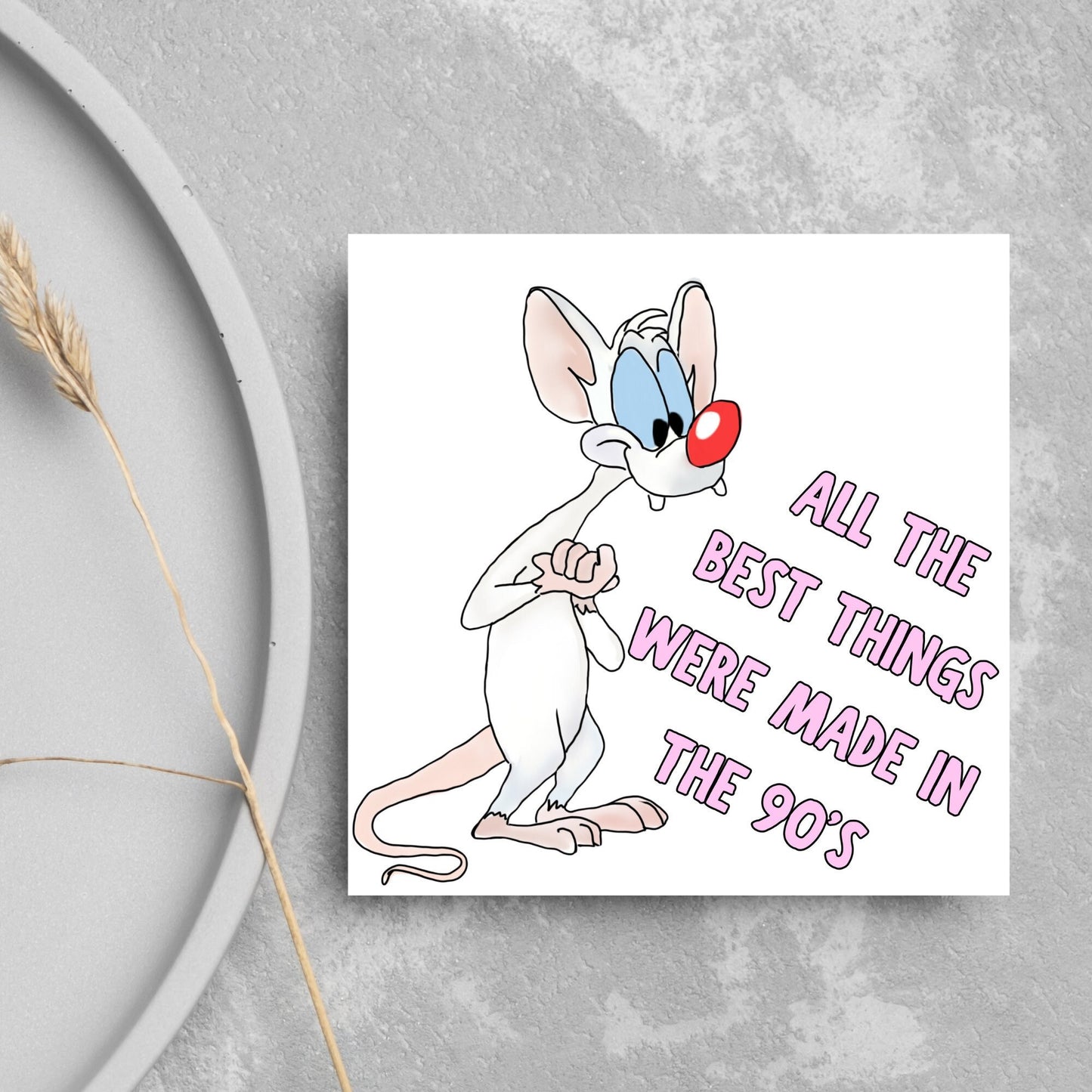 square card featuring an illustration of Pinky from Pinky and the brain with pink text text that reads 'all the best things were' made in the 90's' in the font from the shows title