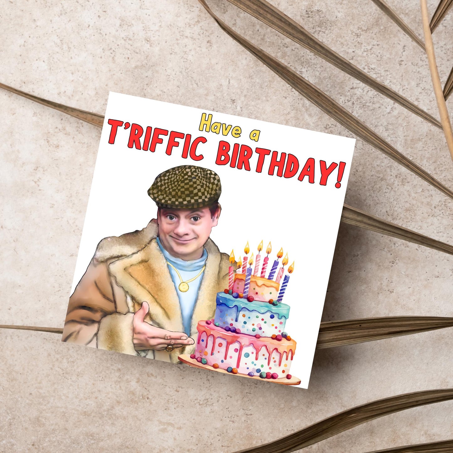 This square shaped card has an illustration of Del Boy from the British Sitcom Only Fools and Horses. The Card has Del Boy standing and pointing at an illustration of a triple tower birthday cake. The Caption reads have a T'riffic Birthday! The Caption is in a mustard yellow and ketchup red