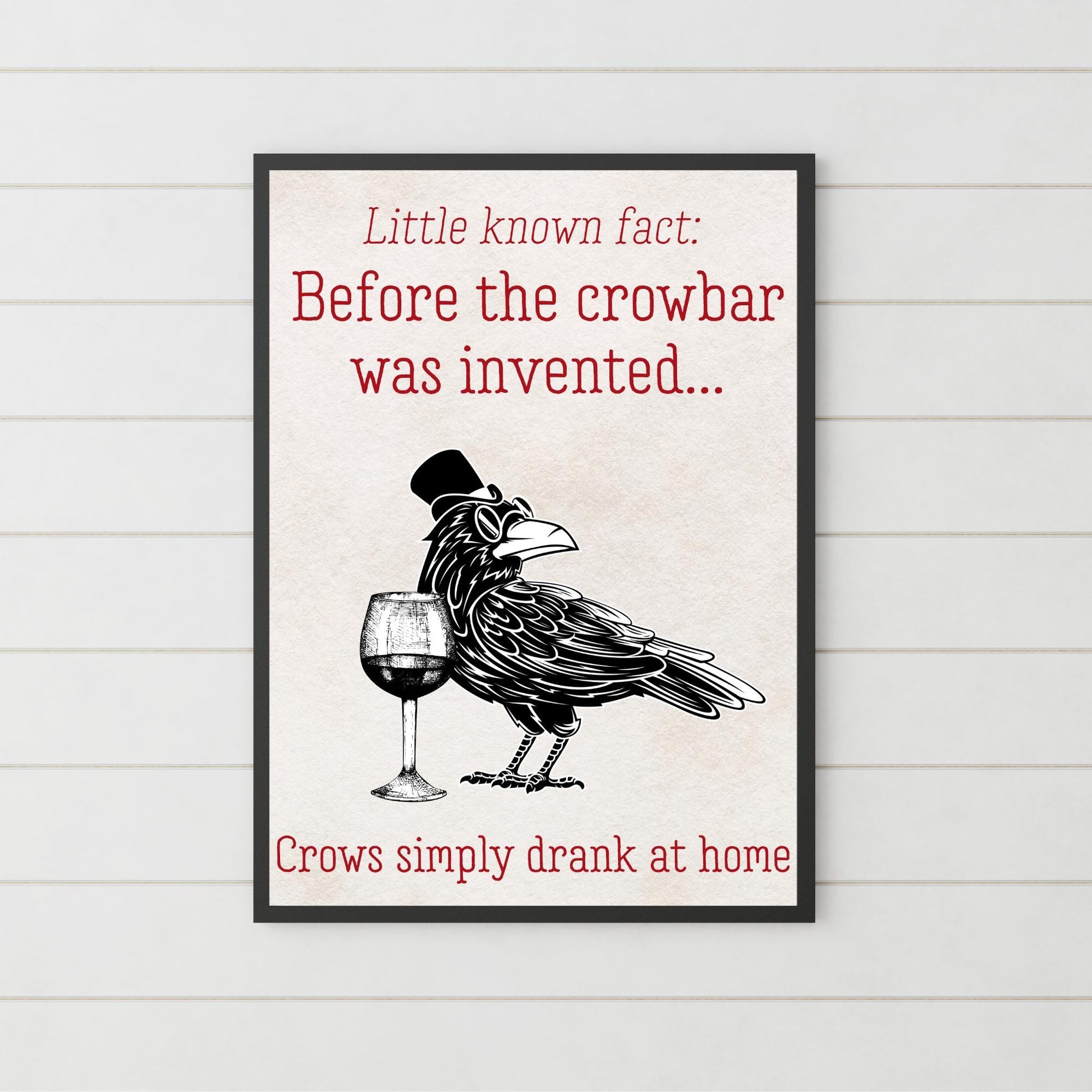 This poster is in an A4 Black bordered frame. Inside of the framed art print poster is an illustration of a crow, with round sunglasses and a top-hat in a black and white monochrome design. Beside the crow is a wine glass. The caption on the poster reads "Little Known Fact: Before the crowbar was invented crows simply drank at home" This poster is perfect for any crow enthusiasts