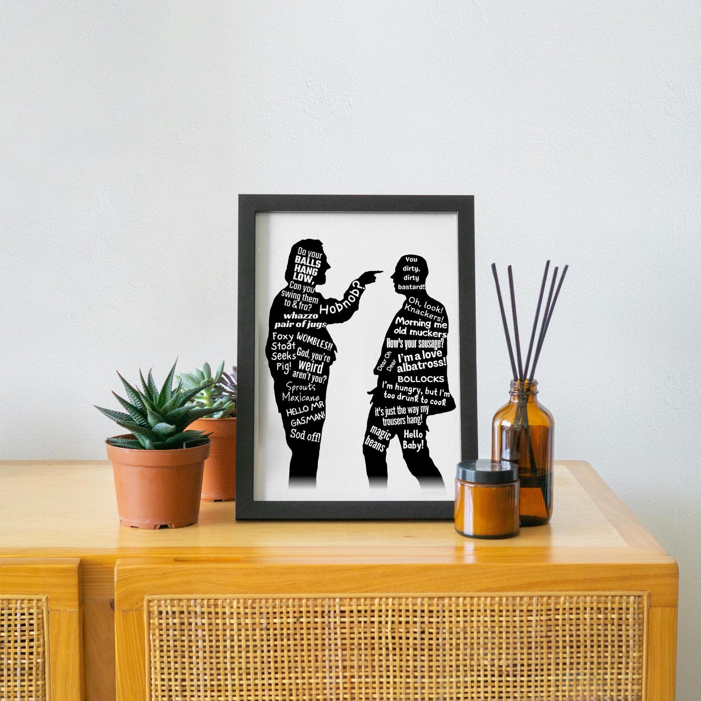 This A4 Poster print is in a simple black frame. The Print has two black silhouettes of Eddy and Richie from the hit BBC Comedy Bottom. Inside of the silhouettes has a selection of bottom quotes such as Do Your balls hang low, Can you swing them to & Fro. Hob Nob? WOMBLES, GASMAN, I'm Hungry but I am too drunk to cook. This poster print is perfect for any bottom fan.