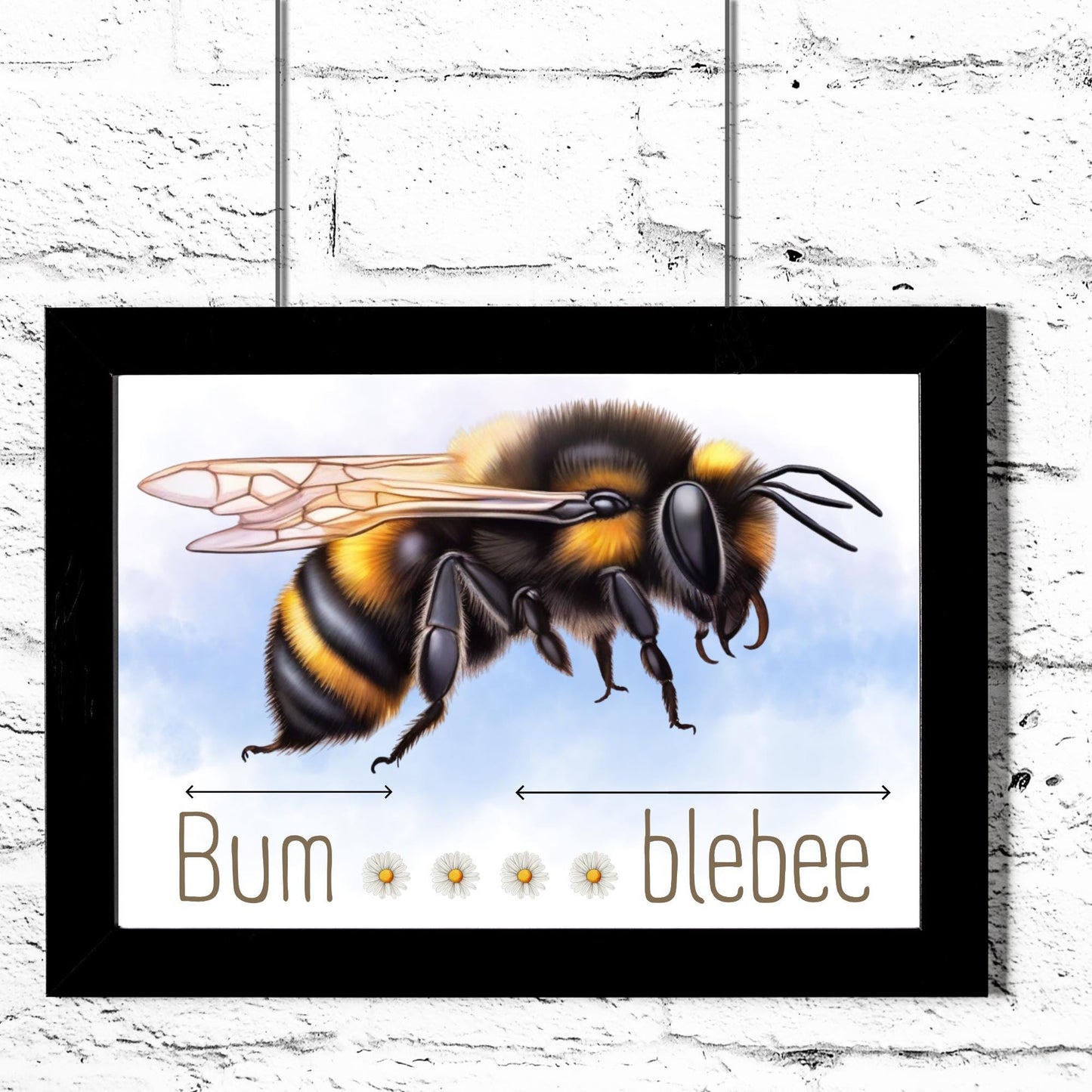 A framed A4 art print featuring a detailed illustration of a bumblebee with soft blue sky in the background. Below the bee, the text playfully reads "Bum" followed by five daisy icons and then "blebee," with arrows pointing across the entire phrase to emphasise the humorous, stretched-out pun