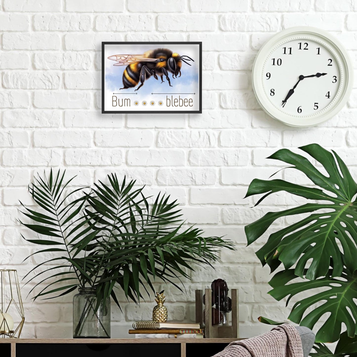 A framed A4 art print featuring a detailed illustration of a bumblebee with soft blue sky in the background. Below the bee, the text playfully reads "Bum" followed by five daisy icons and then "blebee," with arrows pointing across the entire phrase to emphasise the humorous, stretched-out pun