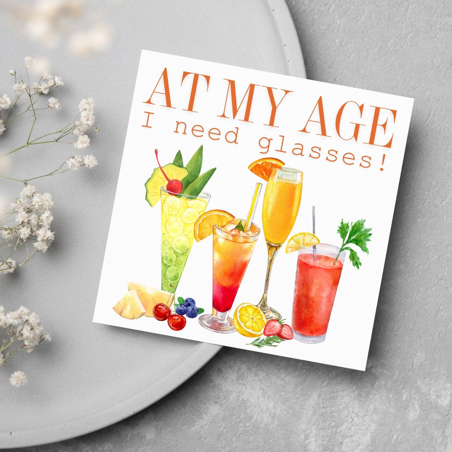 Image of a square birthday card with colourful illustrations of cocktails with the text - at my age I need glasses!