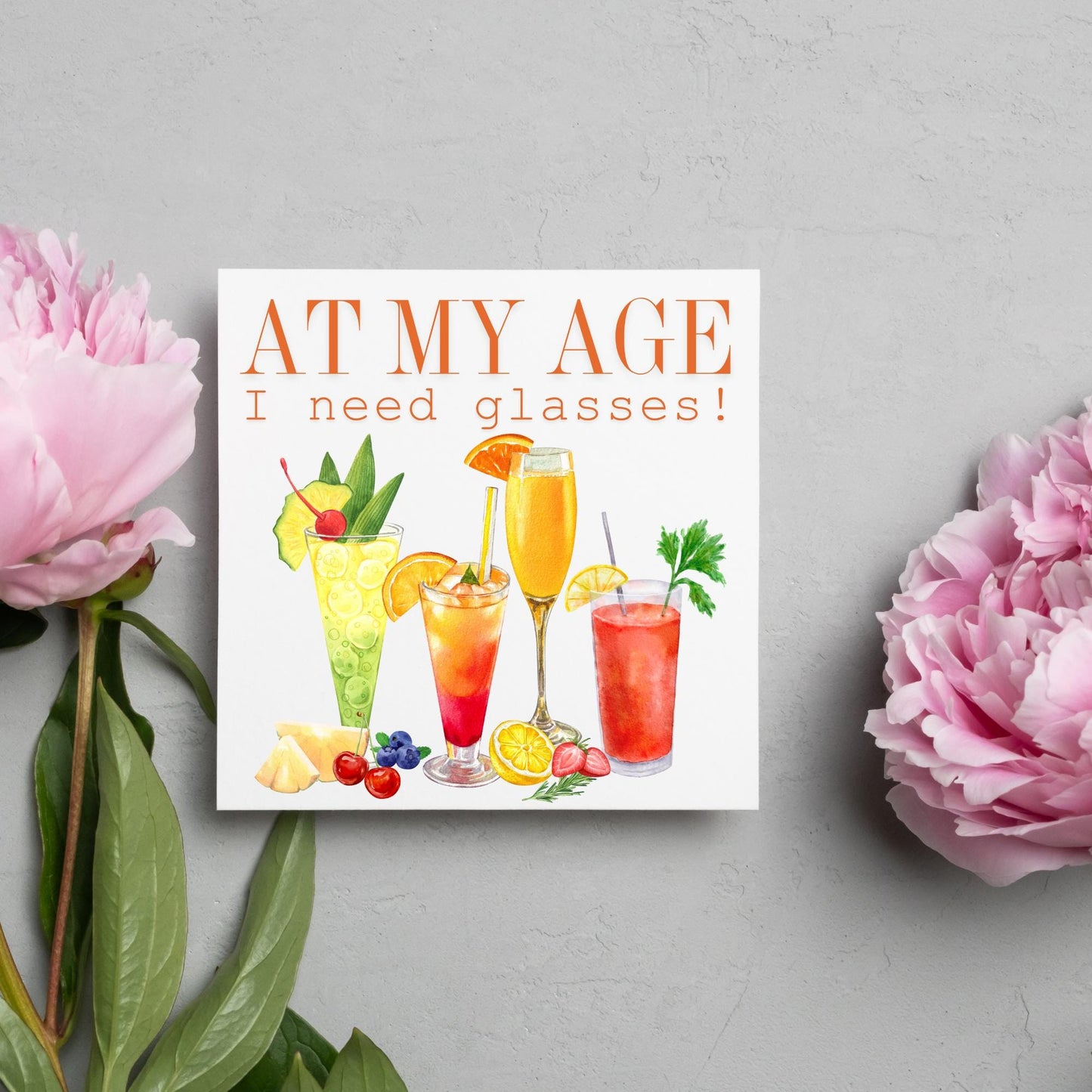 Image of a square birthday card with colourful illustrations of cocktails with the text - at my age I need glasses!