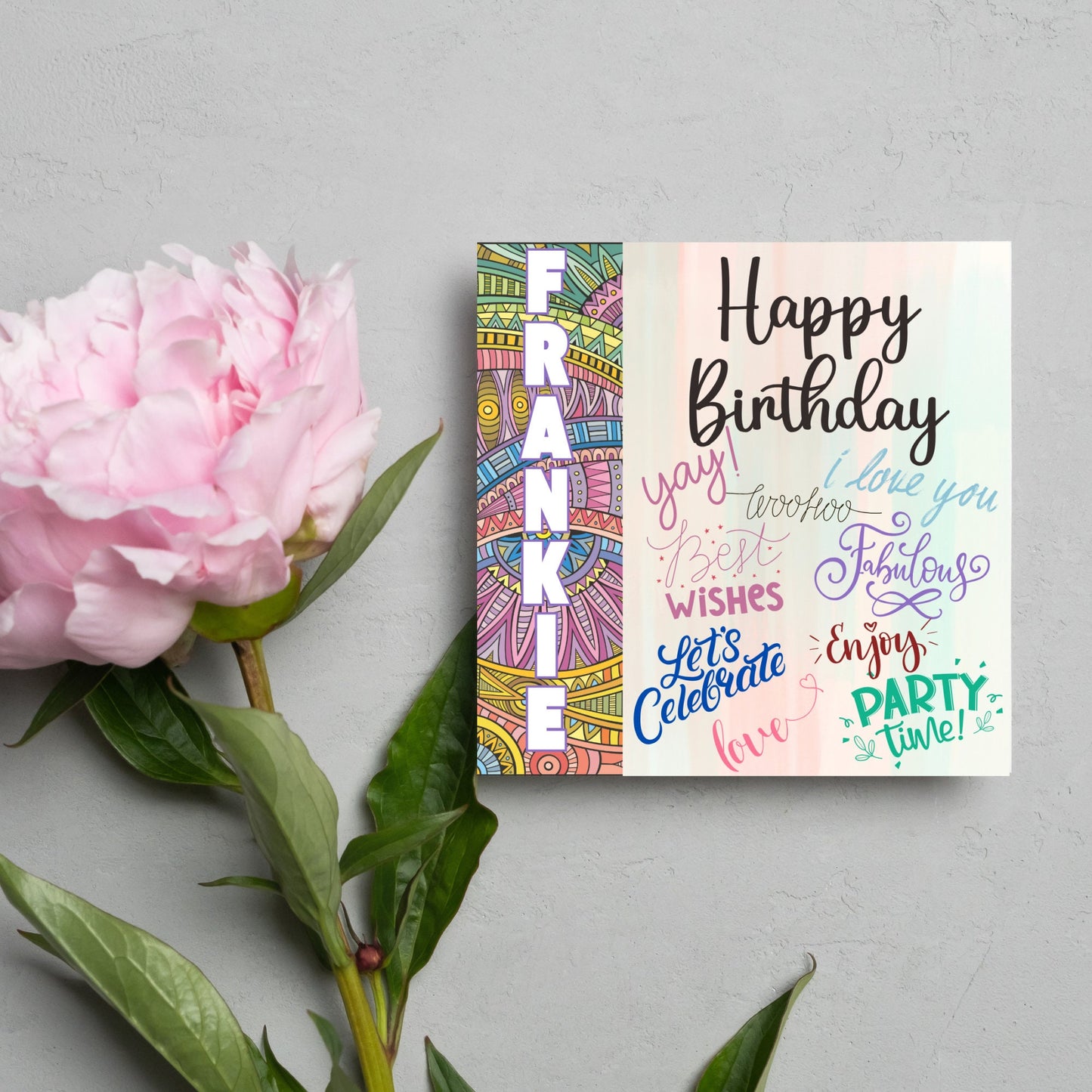 Square birthday card with bold patterned edge with the recipients name overlaid in white. the rest of the card says happy birthday over a pastel background, with messages of yay, I love you, woohoo, best wishes, lets celebrate, enjoy, party time