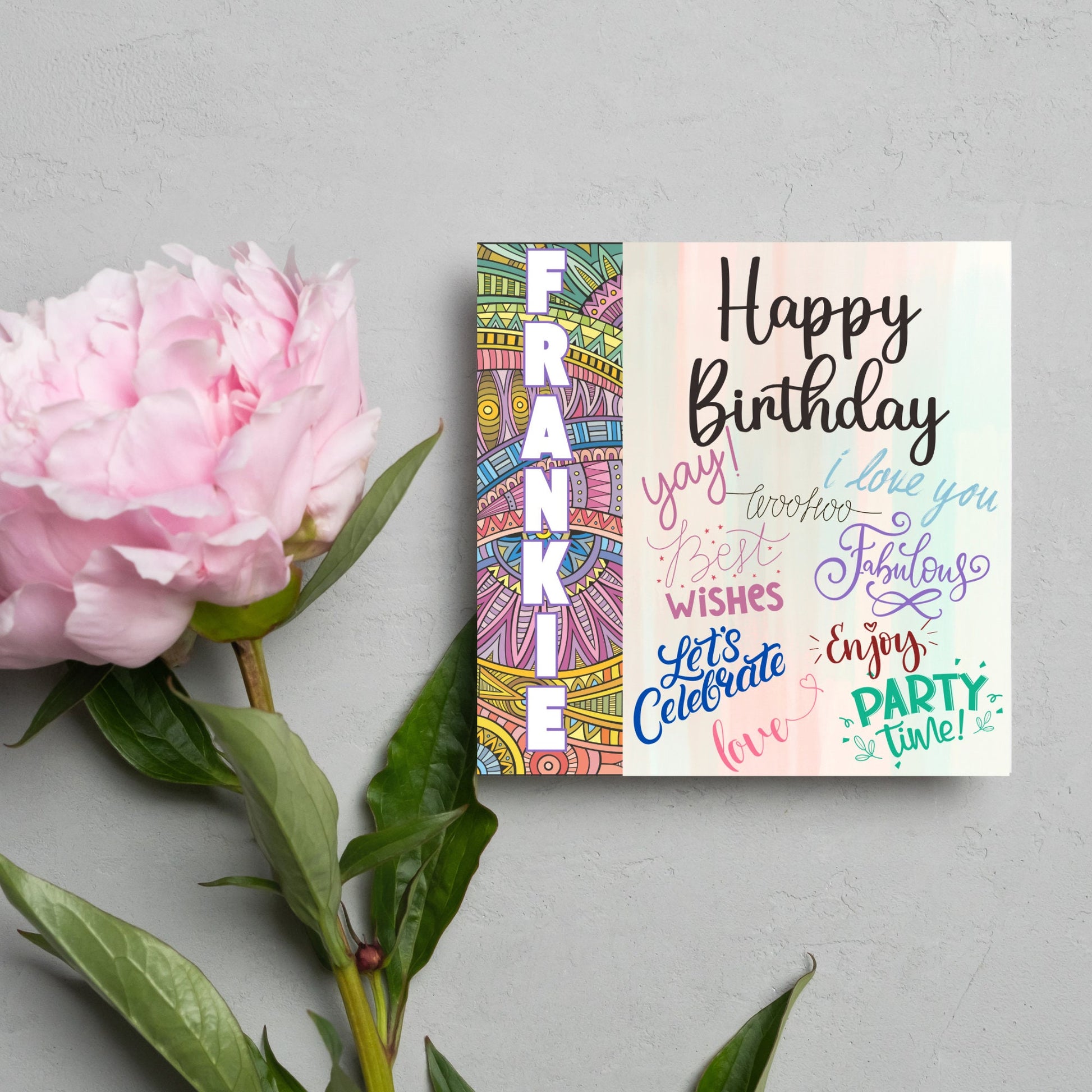 Square birthday card with bold patterned edge with the recipients name overlaid in white. the rest of the card says happy birthday over a pastel background, with messages of yay, I love you, woohoo, best wishes, lets celebrate, enjoy, party time