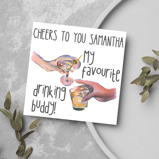 Square card with watercolour design of 2 hands holding drinks glasses against a white background, with grey text that reads &quot;cheers to you Samantha, my favourite drinking buddy&quot;
