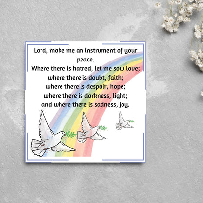 Square greetings card with 3 flying peace doves against a rainbow, with the Prayer of Saint Francis text Lord, make me an instrument of your peace.