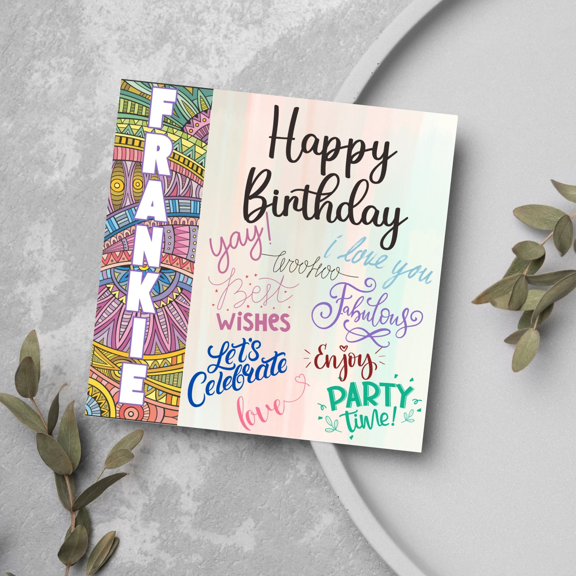 Square birthday card with bold patterned edge with the recipients name overlaid in white. the rest of the card says happy birthday over a pastel background, with messages of yay, I love you, woohoo, best wishes, lets celebrate, enjoy, party time
