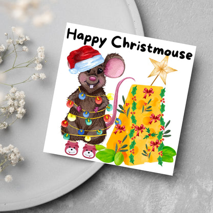 Square Christmas card featuring a cartoon mouse wrapped in christmas lights and wearing a santa hat and slippers next to a christmas tree made from cheese with decorations of holly and red bows. The text, Happy Christmouse is written at the top