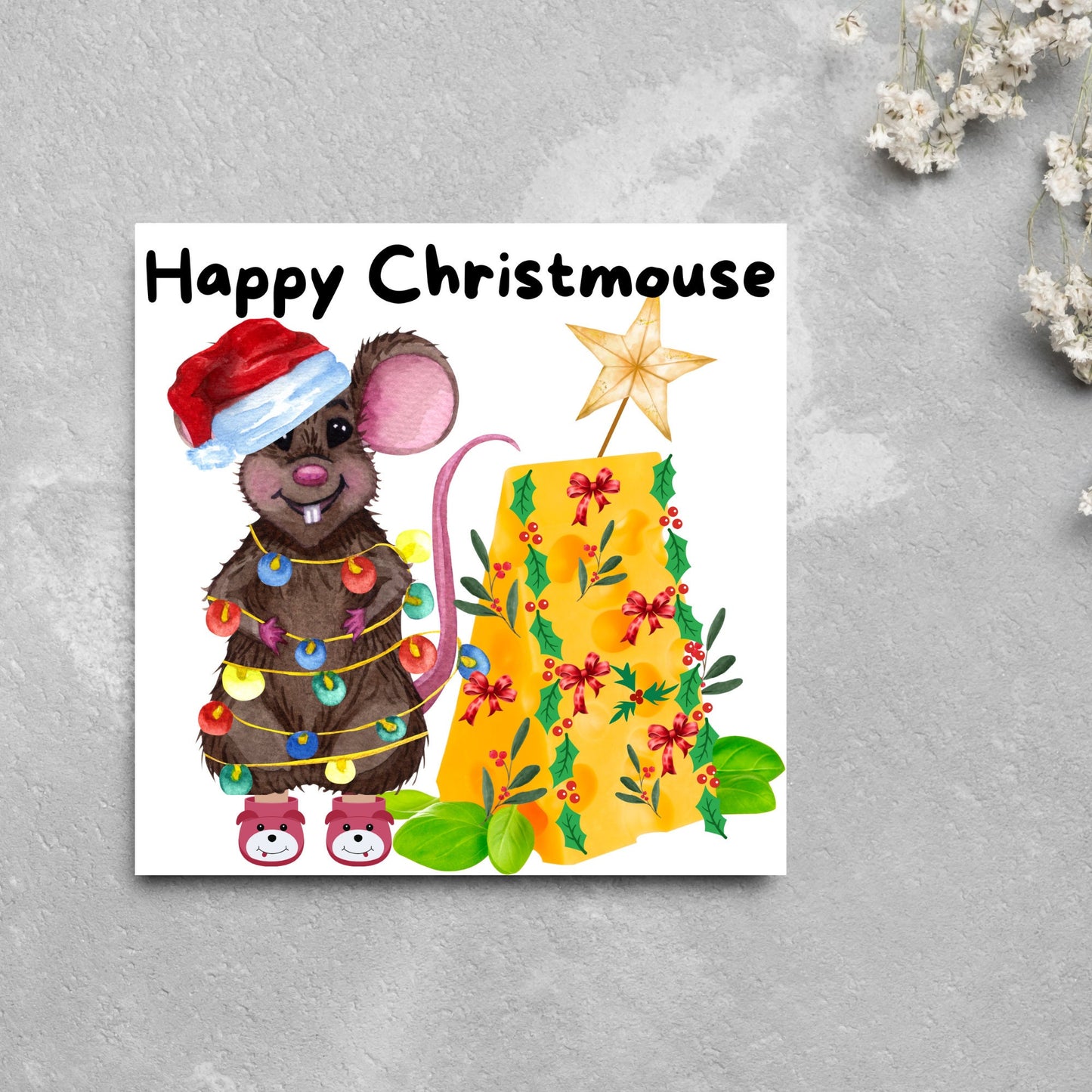 Square Christmas card featuring a cartoon mouse wrapped in christmas lights and wearing a santa hat and slippers next to a christmas tree made from cheese with decorations of holly and red bows. The text, Happy Christmouse is written at the top