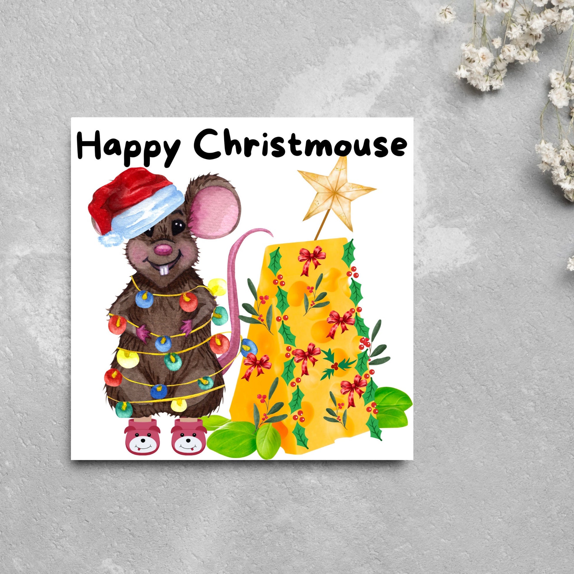 Square Christmas card featuring a cartoon mouse wrapped in christmas lights and wearing a santa hat and slippers next to a christmas tree made from cheese with decorations of holly and red bows. The text, Happy Christmouse is written at the top