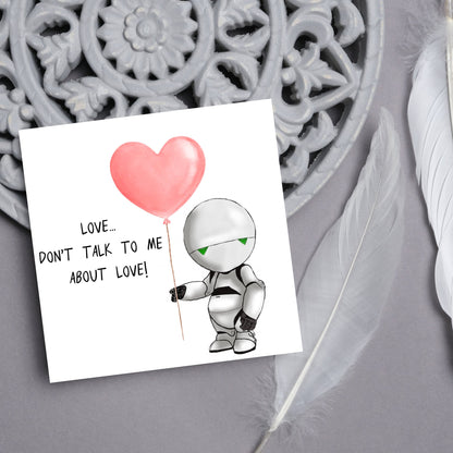 The Square Card has an illistration of Marvin from the classic book, a Hitchhikers guide to the galaxy holding a heart shaped Balloon. It is accompanied by the caption &quot;Love, dont talk to me about Love!&quot;
Funny Love card for boyfriends