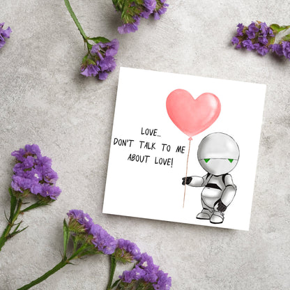 The Square Card has an illistration of Marvin from the classic book, a Hitchhikers guide to the galaxy holding a heart shaped Balloon. It is accompanied by the caption &quot;Love, dont talk to me about Love!&quot;
Funny Love card for boyfriends
