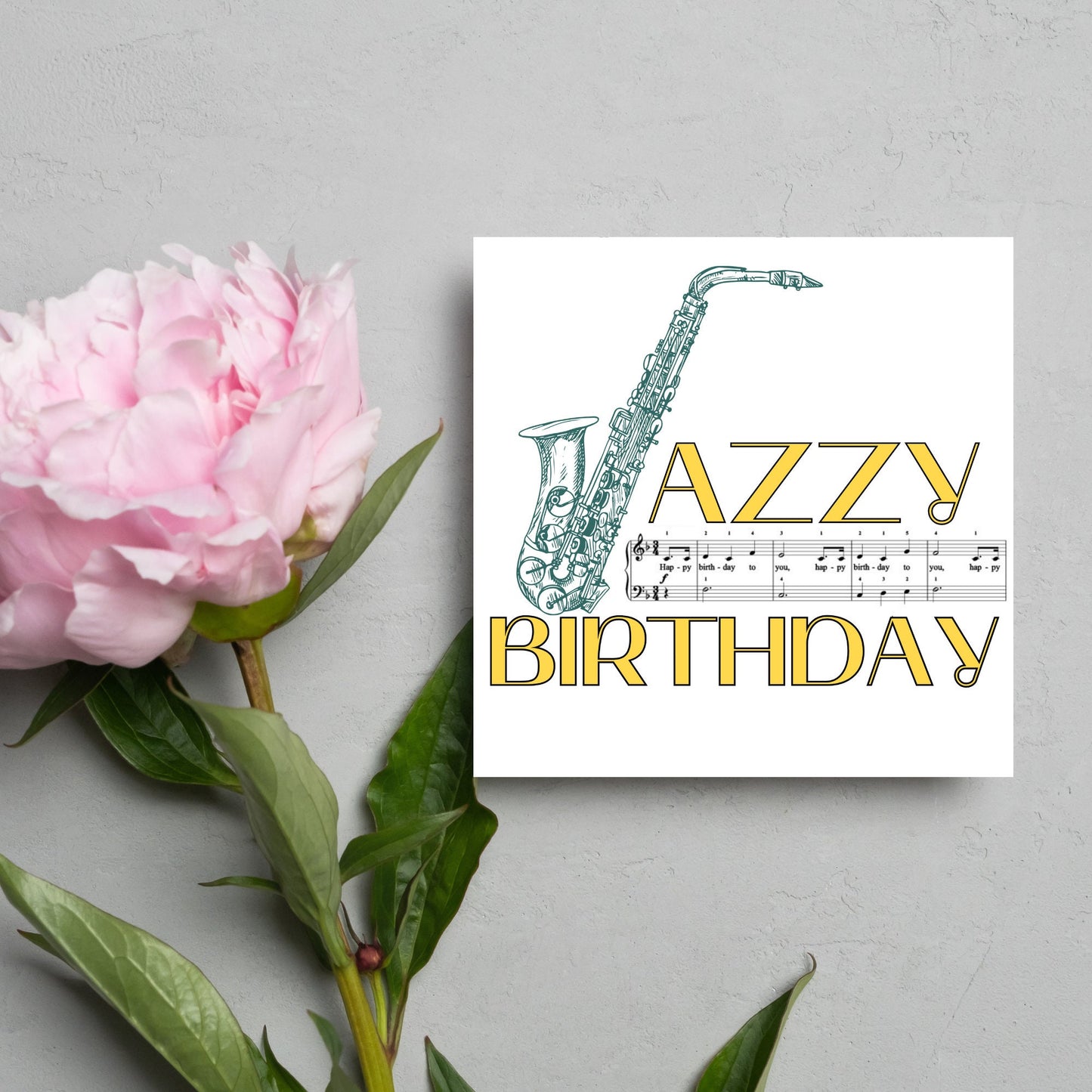 The Birthday Card has an image of a saxaphone in the shape of a &#39;J&#39; along with the word have a Jazzy Birthday. The Card depicts a music sheet of Happy Birthday. This Card is ideal for musicians