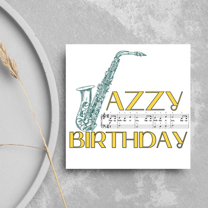The Birthday Card has an image of a saxaphone in the shape of a &#39;J&#39; along with the word have a Jazzy Birthday. The Card depicts a music sheet of Happy Birthday. This Card is ideal for musicians