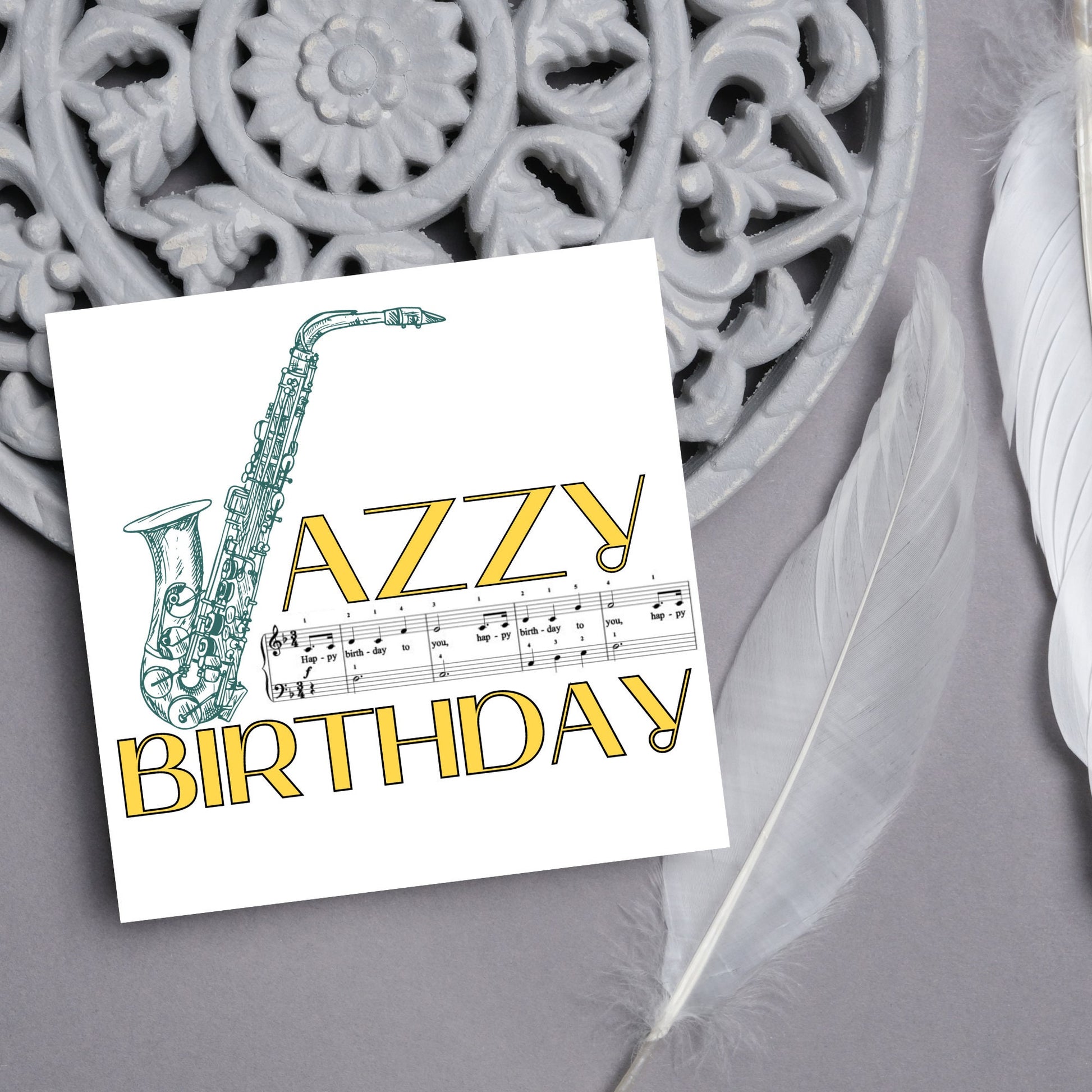 The Birthday Card has an image of a saxaphone in the shape of a &#39;J&#39; along with the word have a Jazzy Birthday. The Card depicts a music sheet of Happy Birthday. This Card is ideal for musicians