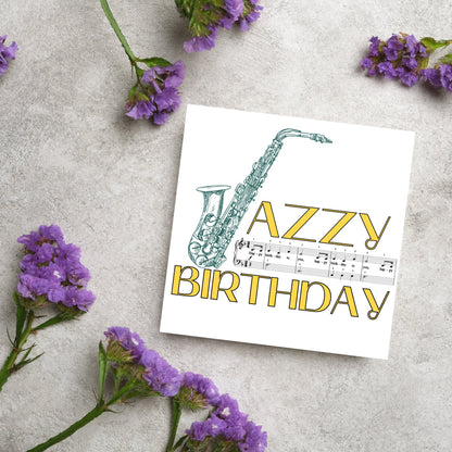 The Birthday Card has an image of a saxaphone in the shape of a &#39;J&#39; along with the word have a Jazzy Birthday. The Card depicts a music sheet of Happy Birthday. This Card is ideal for musicians