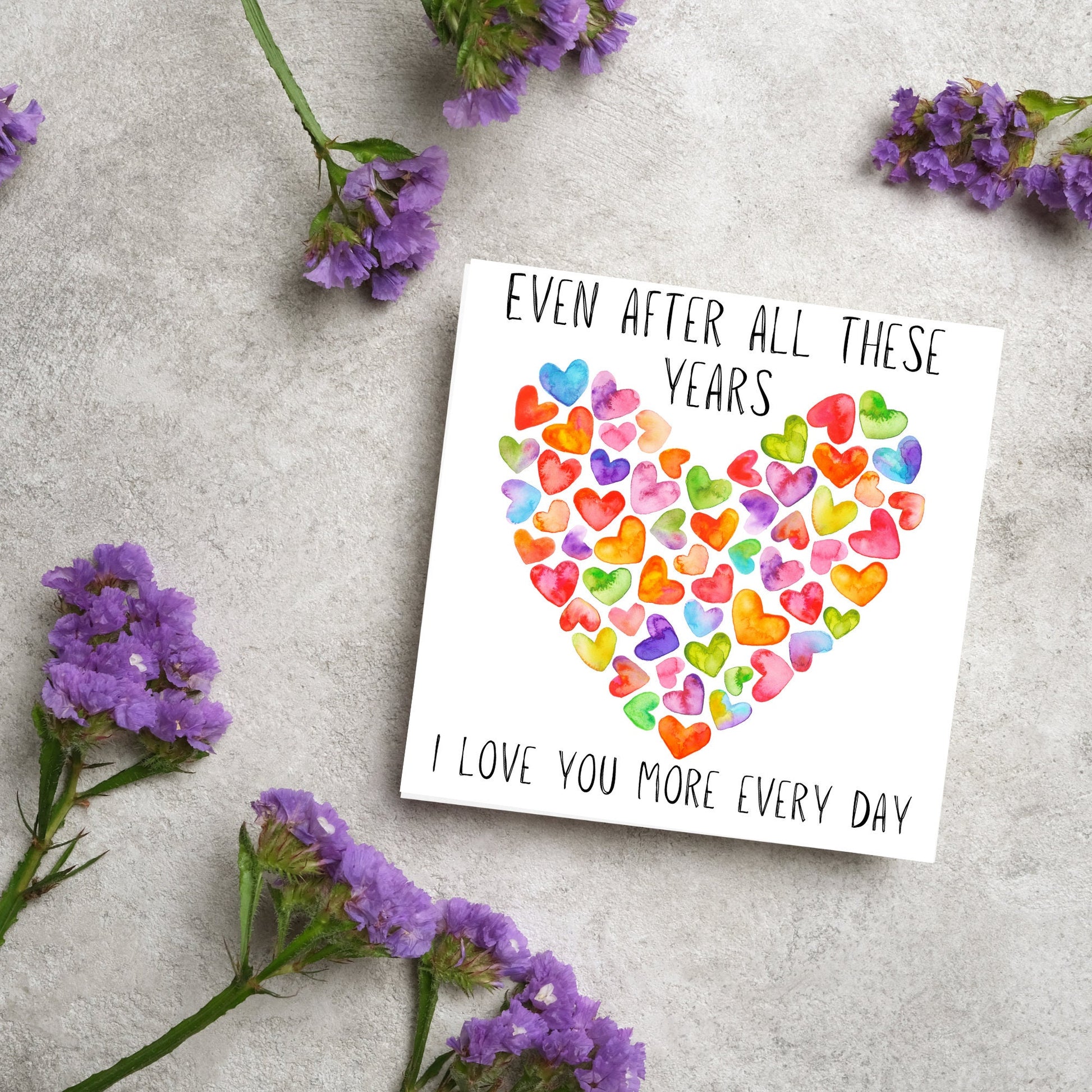 square card with colourful watercolour hearts making one big heart and the text &#39;even after all these years, i love you more everyday&#39; in a handwritten style font