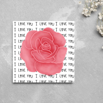 simple elegant card for valentines or anniversary, featuring a large pink rose  painting with a background of handwritten style text that repeats &#39;I love you&#39; with hearts instead of o&#39;s