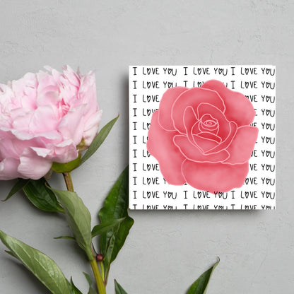 simple elegant card for valentines or anniversary, featuring a large pink rose  painting with a background of handwritten style text that repeats &#39;I love you&#39; with hearts instead of o&#39;s