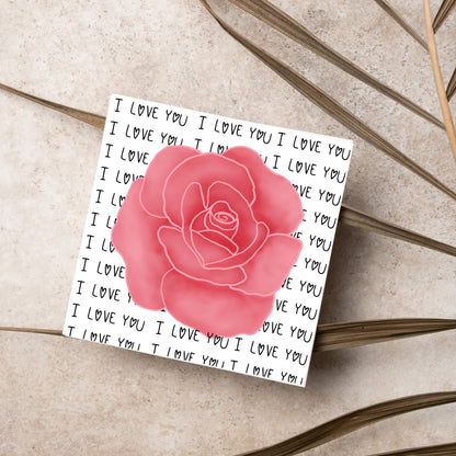 simple elegant card for valentines or anniversary, featuring a large pink rose  painting with a background of handwritten style text that repeats &#39;I love you&#39; with hearts instead of o&#39;s