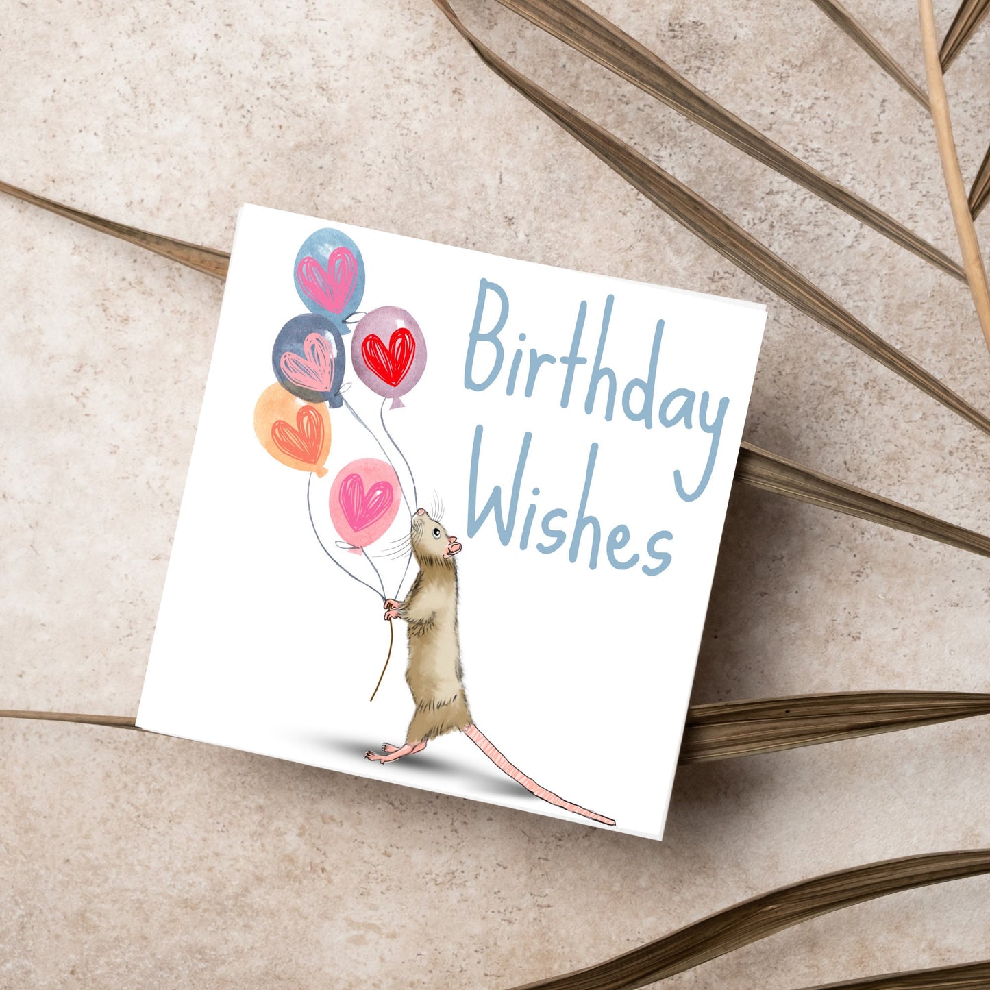 This square card features an illistration of a small mouse/rat holding some balloons with love hearts in a cute cartoon design. The card is captioned Birthday Wishes in a blue handwritten font. The design is on a white background