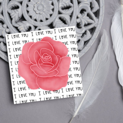 simple elegant card for valentines or anniversary, featuring a large pink rose  painting with a background of handwritten style text that repeats &#39;I love you&#39; with hearts instead of o&#39;s